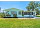 Charming light blue home with well-manicured lawn and landscaping at 1680 Lemon Bay Dr, Venice, FL 34293