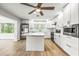 Well-lit kitchen featuring white cabinets, subway tile backsplash, stainless appliances, and a marble island at 1680 Lemon Bay Dr, Venice, FL 34293