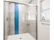 Modern shower with blue tiles and a clear glass sliding door at 1680 Lemon Bay Dr, Venice, FL 34293