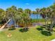 Picturesque waterfront view showcasing a serene body of water framed by towering palm trees and a private dock at 1680 Lemon Bay Dr, Venice, FL 34293