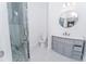 Well lit bathroom featuring tiled shower, modern sink, contemporary mirror, and white walls at 18182 Steele Ave, Port Charlotte, FL 33948