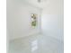Bright, airy bedroom with a window overlooking green foliage and sleek tile flooring at 18182 Steele Ave, Port Charlotte, FL 33948
