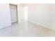 Bright, minimalist bedroom with white walls and tile floors, featuring closet and doorway at 18182 Steele Ave, Port Charlotte, FL 33948
