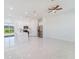Bright, open-concept living space featuring modern white tile flooring, recessed lighting, and a ceiling fan at 18182 Steele Ave, Port Charlotte, FL 33948