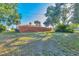 Large backyard with a tall wooden fence, grass, and mature trees at 2301 Cass St, Sarasota, FL 34231
