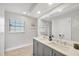 Bright bathroom offers double sinks with quartz countertops, updated vanity, and a decorative mirror at 2301 Cass St, Sarasota, FL 34231