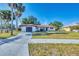 Charming single-story home features a well-manicured lawn and a driveway leading to an attached garage at 2301 Cass St, Sarasota, FL 34231