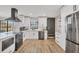 Modern kitchen features white cabinets, stainless steel appliances, and a stylish black range hood at 2301 Cass St, Sarasota, FL 34231
