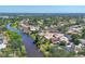 Aerial view showcases neighborhood along water, pools, and well-maintained homes in a tranquil community setting at 2410 Tanglewood Dr, Sarasota, FL 34239