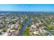 Aerial view shows neighborhood homes, river, and lush greenery, highlighting a serene community setting at 2410 Tanglewood Dr, Sarasota, FL 34239