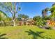Scenic backyard featuring Adirondack chairs, lush landscaping, and serene water views, perfect for outdoor relaxation at 2410 Tanglewood Dr, Sarasota, FL 34239