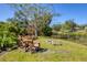 Backyard with Adirondack chairs, a fire pit, and lush landscaping, ideal for gatherings and outdoor enjoyment at 2410 Tanglewood Dr, Sarasota, FL 34239