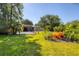 Lush backyard with patio offers serene retreat; home has yellow paint and lots of greenery at 2410 Tanglewood Dr, Sarasota, FL 34239