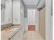 Bathroom featuring marble counters, white cabinets, and a view to the hallway at 2410 Tanglewood Dr, Sarasota, FL 34239