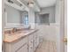 Bathroom featuring double sinks, white cabinets, and a large window at 2410 Tanglewood Dr, Sarasota, FL 34239