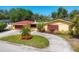 Charming yellow home features a circular driveway and well-manicured landscaping at 2410 Tanglewood Dr, Sarasota, FL 34239