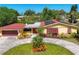Charming single-Gathering home featuring a red roof, solar panels, and well-manicured front yard landscaping at 2410 Tanglewood Dr, Sarasota, FL 34239