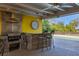 Close-up of the outdoor kitchen featuring a stone bar, grill, and ample counter space at 2410 Tanglewood Dr, Sarasota, FL 34239
