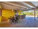 Charming covered patio with an outdoor kitchen, dining area, and bar overlooking the pool at 2410 Tanglewood Dr, Sarasota, FL 34239