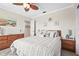 Cozy bedroom features a decorative ceiling fan, beach-themed art, and a comfortable bed with wood furnishings at 2531 Riverbluff Pkwy # V181, Sarasota, FL 34231