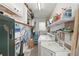 Functional laundry room with washer, dryer, sink, storage cabinets, shelving, and beach gear at 2531 Riverbluff Pkwy # V181, Sarasota, FL 34231