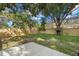 Large backyard with a concrete patio, wooden fence, and lush landscaping at 2535 Floyd St, Sarasota, FL 34239