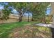 Spacious backyard featuring a large wall, mature trees and lawn at 2535 Floyd St, Sarasota, FL 34239