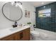 Updated bathroom with blue tile accent wall, modern vanity, and updated light fixtures at 2535 Floyd St, Sarasota, FL 34239
