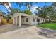 Beautiful home featuring an expansive driveway, carport, manicured lawn, and freshly painted white exterior at 2535 Floyd St, Sarasota, FL 34239