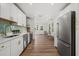 Modern kitchen featuring white cabinets, stainless steel appliances, and a view to the dining area at the end at 2535 Floyd St, Sarasota, FL 34239