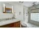 Modern bathroom with a glass-enclosed shower, tile flooring, and a wood vanity at 2598 Wood St, Sarasota, FL 34237