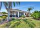 Lush backyard with covered patio, palm trees, and well-manicured lawn at 3103 77Th E Dr, Sarasota, FL 34243