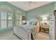 Serene bedroom features soft blue walls, shuttered windows, and stylish bedside tables at 3103 77Th E Dr, Sarasota, FL 34243