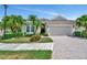 Beautiful single-story home with a paver driveway, well-manicured lawn, and tropical landscaping at 3103 77Th E Dr, Sarasota, FL 34243