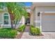 Inviting front entrance featuring a brick walkway, lush landscaping, and a charming palm tree at 3103 77Th E Dr, Sarasota, FL 34243