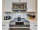 Close-up of a modern stove with stainless steel accents and stylish tile backsplash detail at 3103 77Th E Dr, Sarasota, FL 34243
