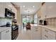 Spacious kitchen with stainless steel appliances, white cabinets, and a breakfast nook with a view at 3103 77Th E Dr, Sarasota, FL 34243