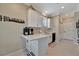 Modern kitchenette featuring sleek white cabinetry, a stylish backsplash, and stainless steel appliances at 3103 77Th E Dr, Sarasota, FL 34243