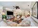 Bright living room featuring plush seating, a large TV, and elegant decor, ideal for relaxation at 3103 77Th E Dr, Sarasota, FL 34243