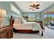 Bright main bedroom with wood furniture, a ceiling fan, and access to the patio at 3103 77Th E Dr, Sarasota, FL 34243