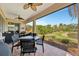 Covered patio with table, chairs, fans, and an open view of the green lawn at 3103 77Th E Dr, Sarasota, FL 34243
