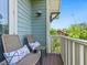 Charming balcony seating with decorative pillows and view of the neighborhood trees and sky at 324 Julia Pl, Sarasota, FL 34236