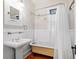 Bright bathroom with claw foot tub, pedestal sink and wooden floors at 324 Julia Pl, Sarasota, FL 34236