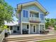 Two-story home with a balcony features an outdoor grill, patio, backyard, and lush greenery at 324 Julia Pl, Sarasota, FL 34236