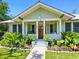 Inviting front porch with a wooden door and tropical landscaping at 324 Julia Pl, Sarasota, FL 34236