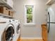 Functional laundry room with modern washer and dryer, shelving, and a small window at 324 Julia Pl, Sarasota, FL 34236