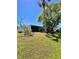 Lush green backyard with mature trees and a screened-in lanai, creating a serene outdoor space at 3325 Honeymoon Ln, Holiday, FL 34691