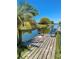 Beautiful backyard featuring a wooden dock with seating, overlooking a pond at 3325 Honeymoon Ln, Holiday, FL 34691