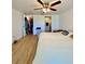 Bedroom featuring laminate flooring, a ceiling fan, and access to an ensuite bathroom and walk-in closet at 3325 Honeymoon Ln, Holiday, FL 34691