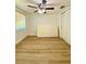 Bedroom with laminate flooring, a ceiling fan, a window, and a closet with sliding doors at 3325 Honeymoon Ln, Holiday, FL 34691